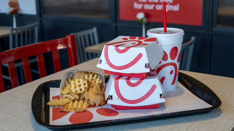 Chick-fil-A sandwiches, fries, and a drink on a black tray