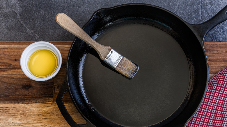 Cast iron skillet being seasoned with oil