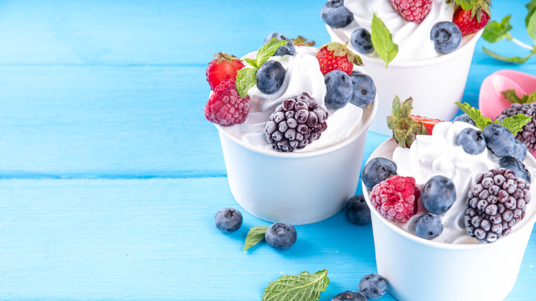 Vanilla frozen yogurt with berries in white cups
