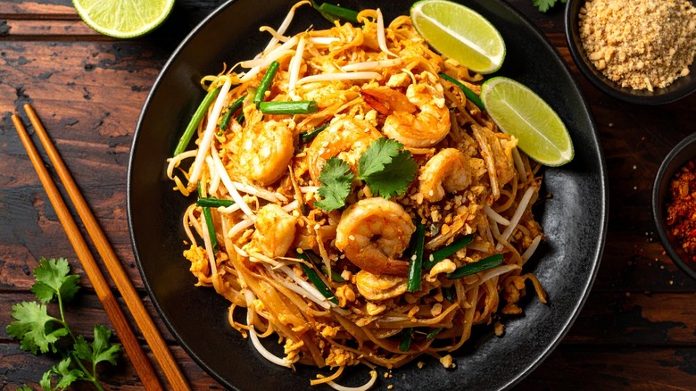 A pad thai with shrimp and lime.