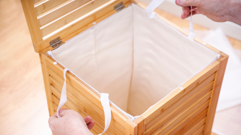 Liner being put inside a square wooden hamper