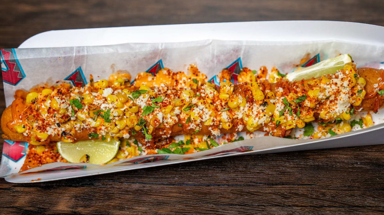 Foot-long corn dog topped with elote-style toppings