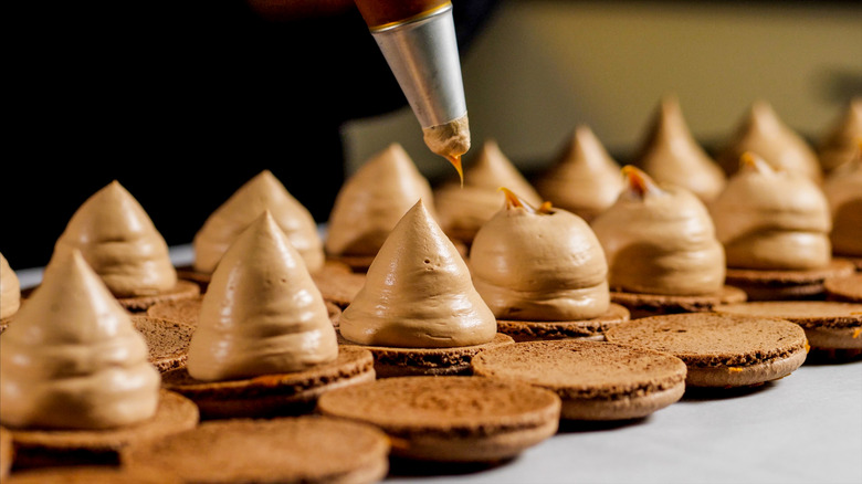 Piping cream onto macaron shells