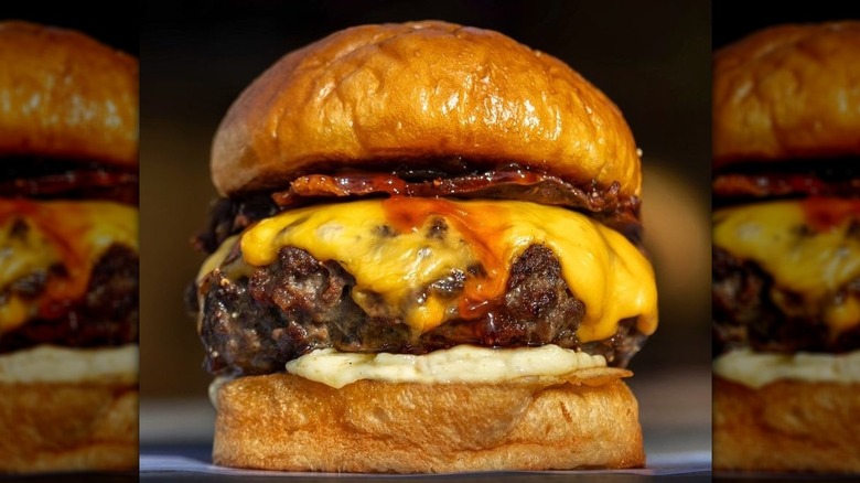 Burger with cheese, bacon, and sauce on a thick bun
