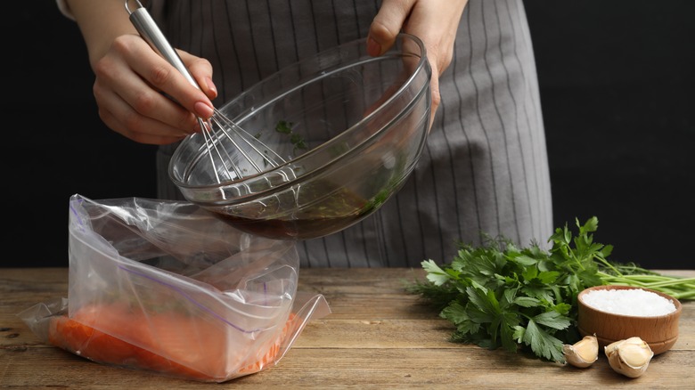 Woman pouring marinade into a bag of meat