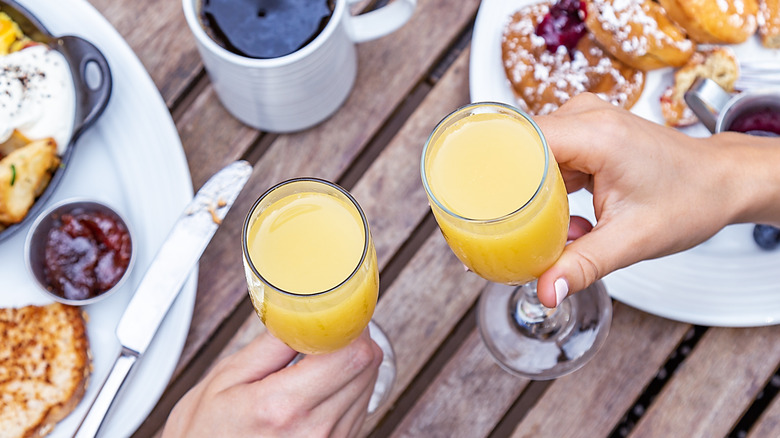 People toasting mimosas at brunch.