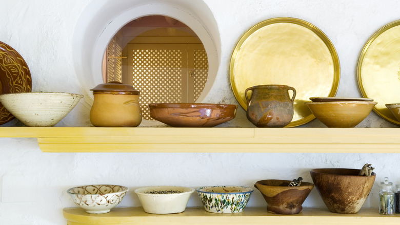 Colorful ceramic cookery on open kitchen shelves