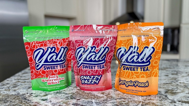 Three bags of decaffeinated sweet tea sit on a counter top in watermelon, raspberry, and peach flavors