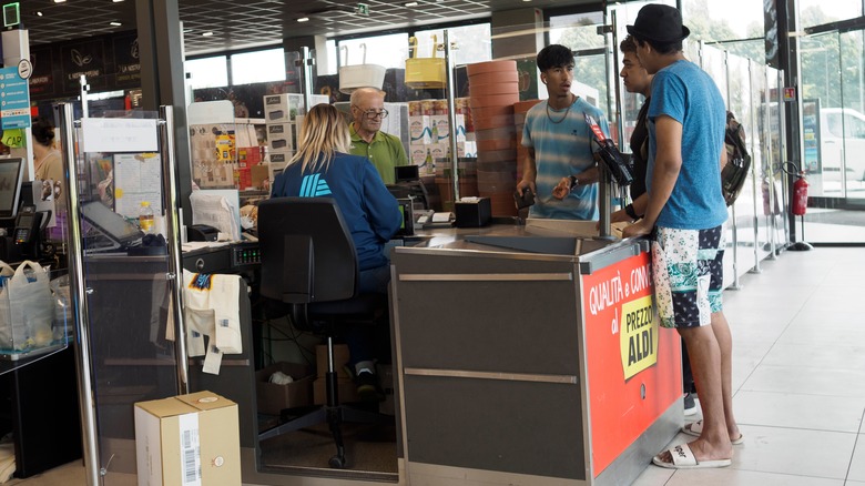 An Aldi employee sits at the register