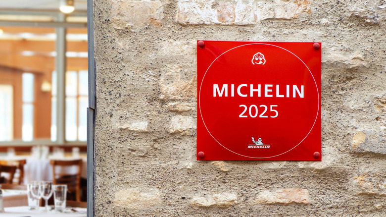 Red Michelin star plaque on stone wall outside a restaurant
