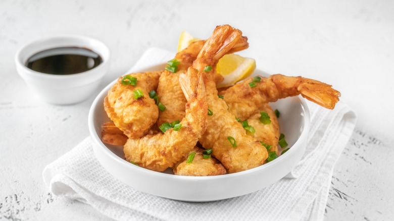 Shrimp tempura in bowl with dipping sauce 