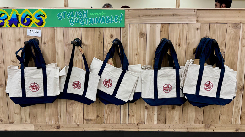 Trader Joe's canvas totes hang from five pegs