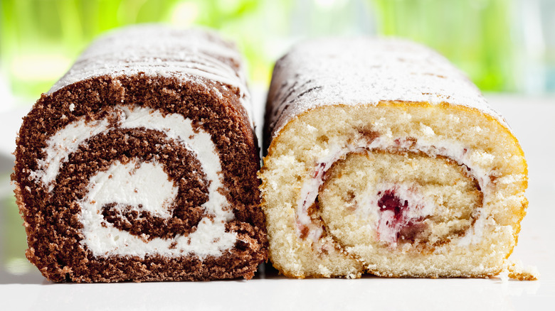 Chocolate Swiss roll cake next to vanilla and fruit Swiss roll cake