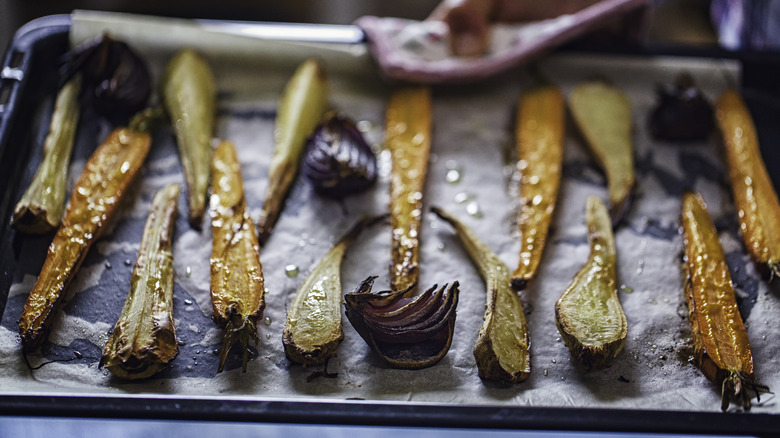 Roasted carrots and onions on parchment paper