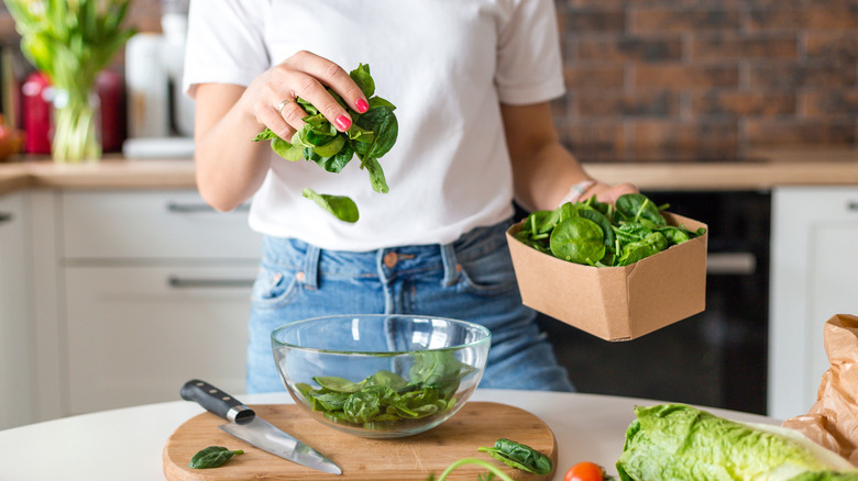 A home cook making a spinach salad