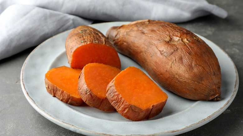 A sweet potato sliced on a gray plate