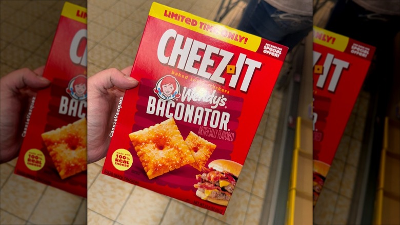 A hand holds a box of Wendy's Baconator Cheez-its