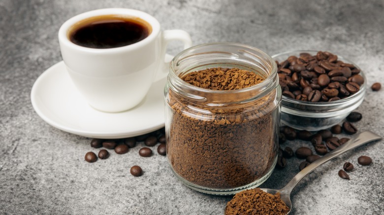 cup of coffee next to jar of instant coffee