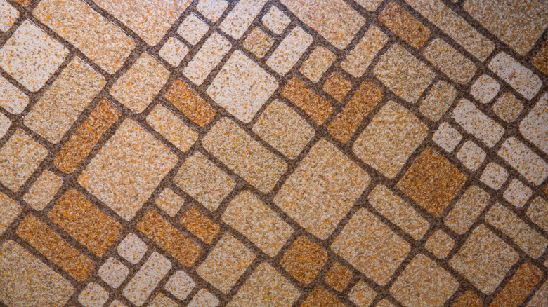 Closeup of old-school vinyl flooring in a pattern of brown squares and rectangles