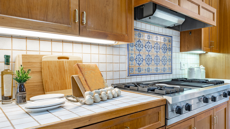 A kitchen that has tile in the backsplash and a tile countertop