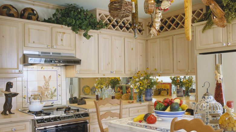 Kitchen with baskets and plants placed atop cabinets