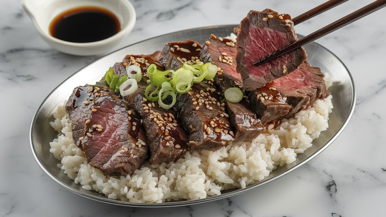 A steak and rice dinner with a sweet glaze