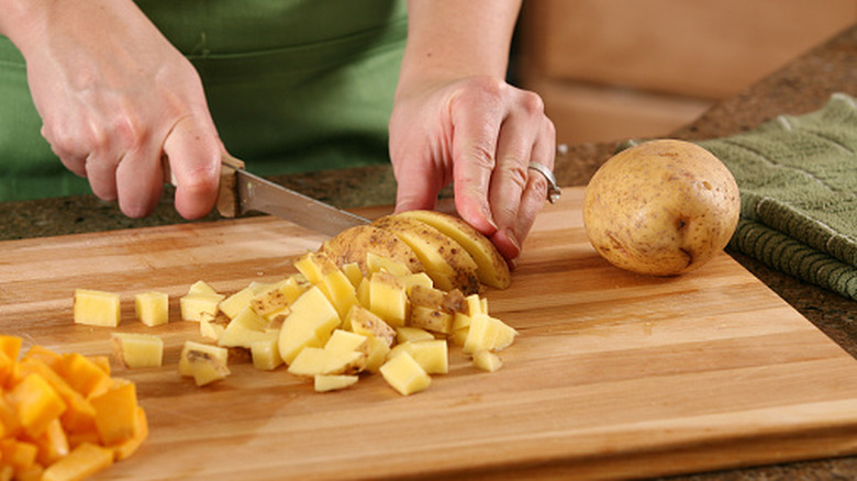 Person chopping potatoes