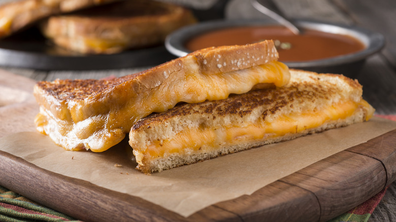 Grilled cheese sandwich sits in front of a cast iron skillet