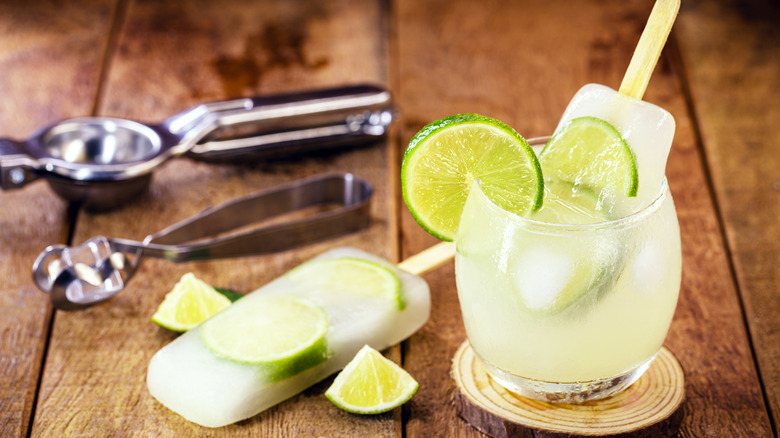 lime cocktail popsicle stuck in a glass
