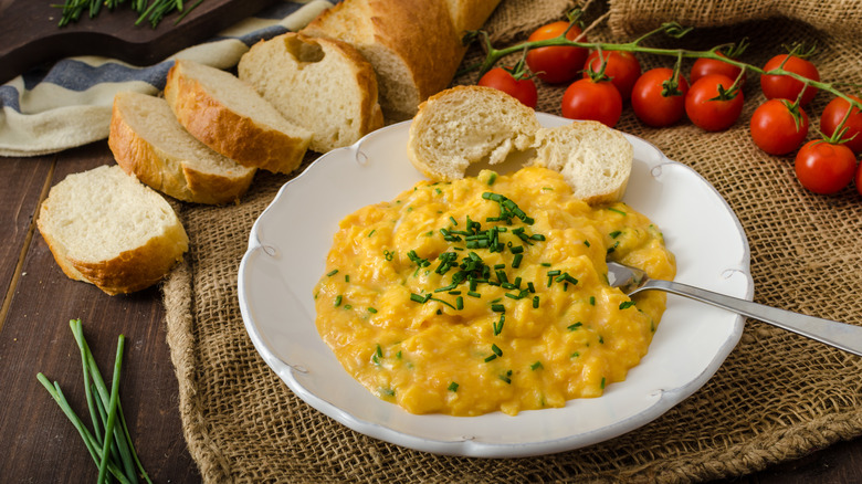 French scrambled eggs with chives, tomatoes, and baguette slices