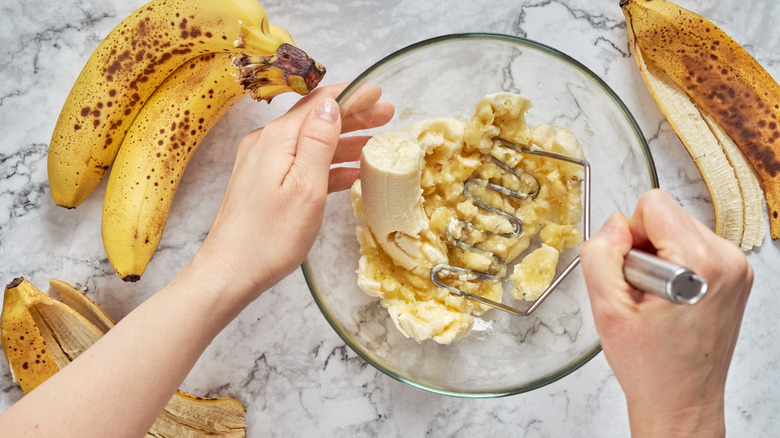 Person mashing bananas in a bowl