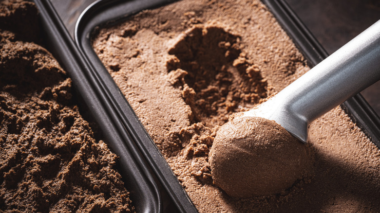 Scooping ice cream from a bread pan.
