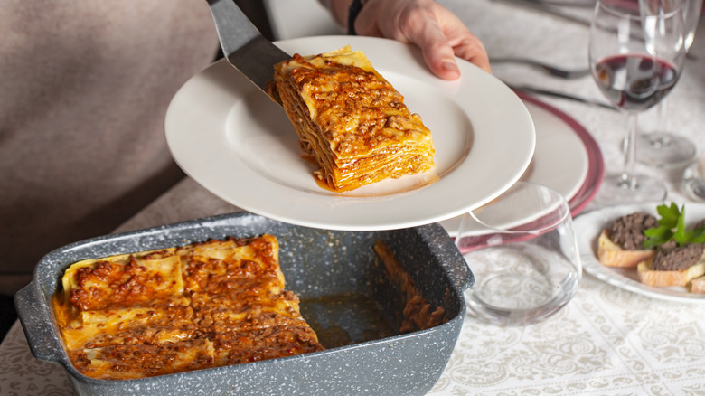 Serving lasagna out of a bread pan.