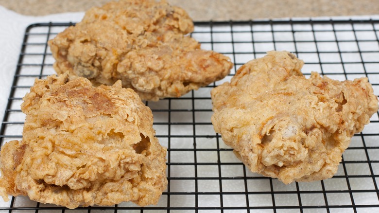 draining fried chicken on wire rack