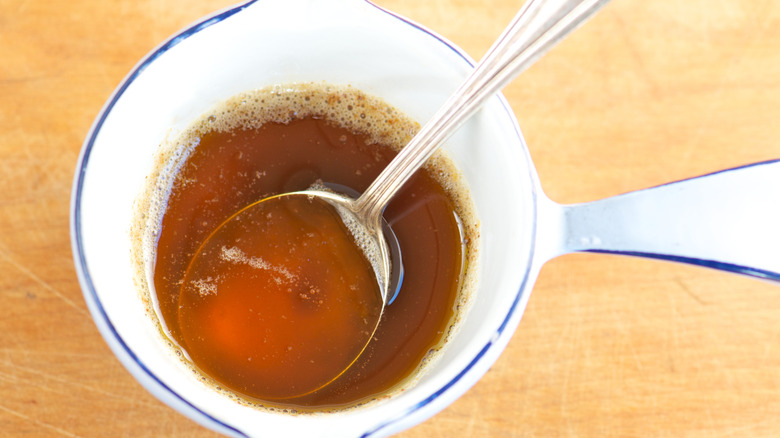A pot of brown butter with a spoon taking out a scoop