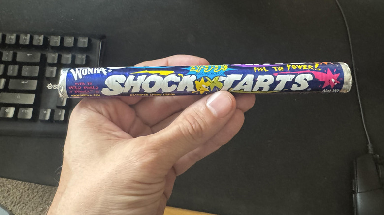 A hand holds a Shock Tarts roll.