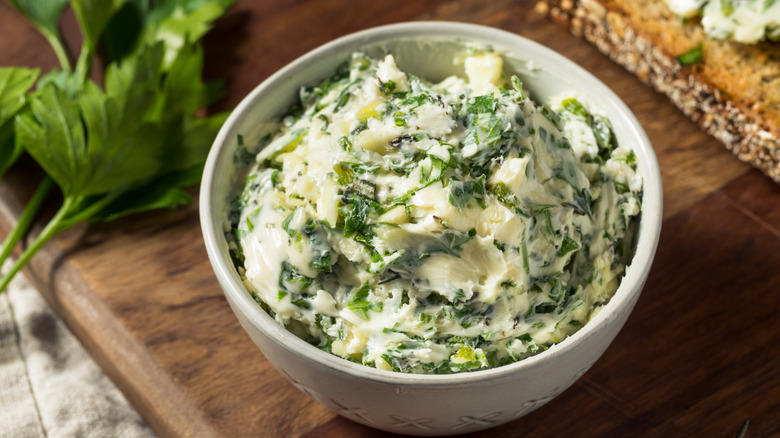 A small white bowl of herby garlic butter