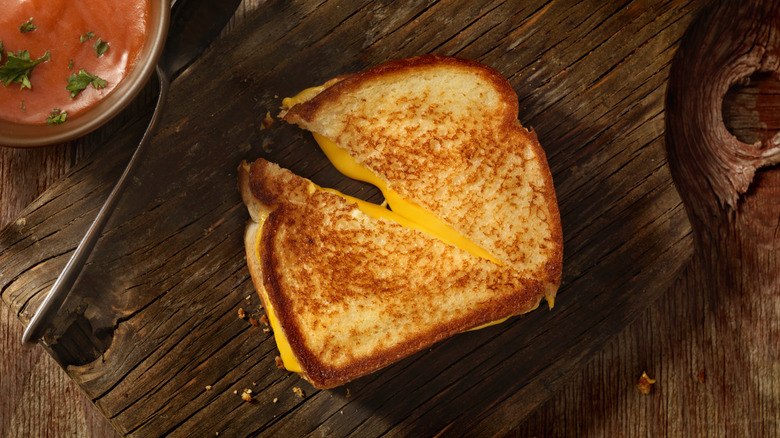 diagonally sliced grilled cheese sandwich on a wooden cutting board