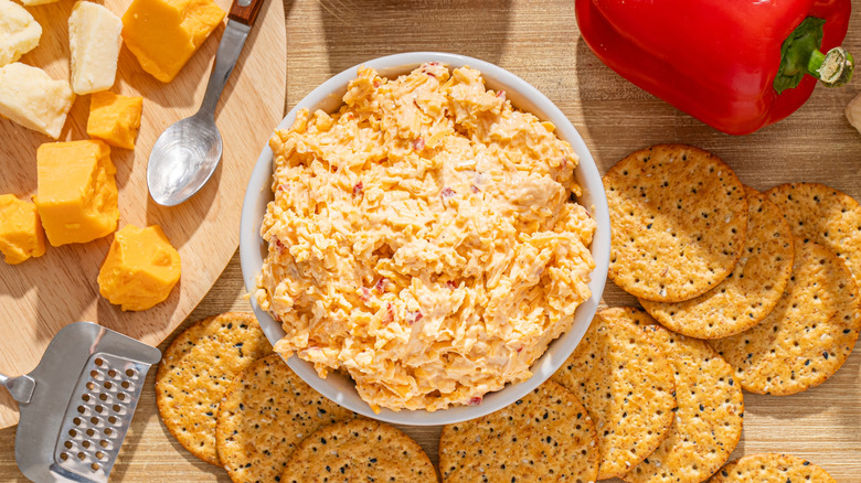 A bowl of pimento cheese with crackers