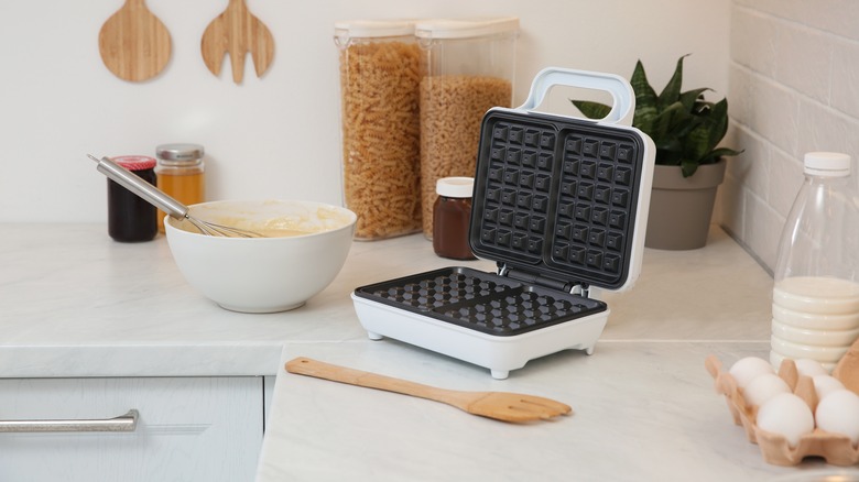 Bowl of batter next to waffle iron in kitchen