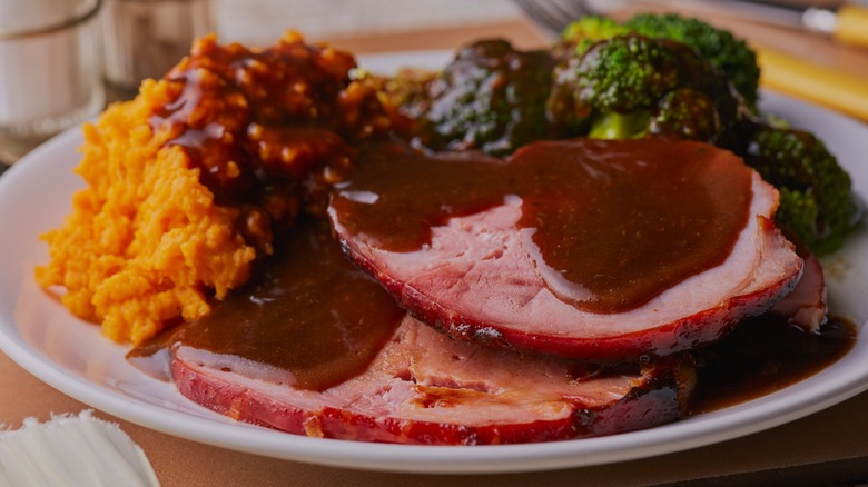 Plate with ham, mashed sweet potatoes, broccoli, and dark gravy