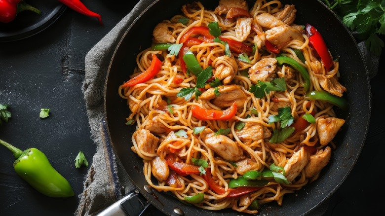 Stir fry with noodles and chicken in pan
