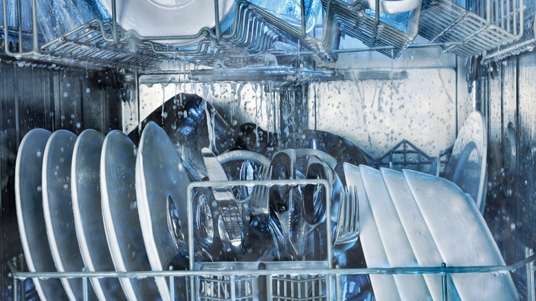 The interior of a dishwasher with dishes in it