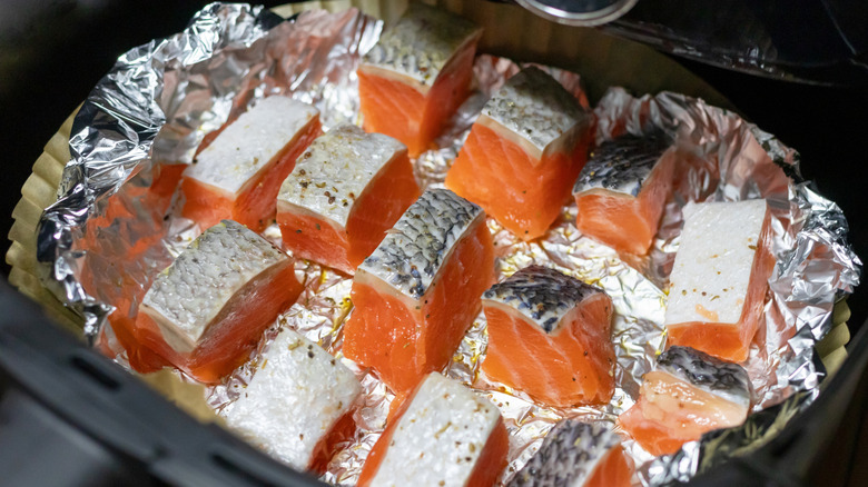 Chunks of salmon cooking in foil in the air fryer