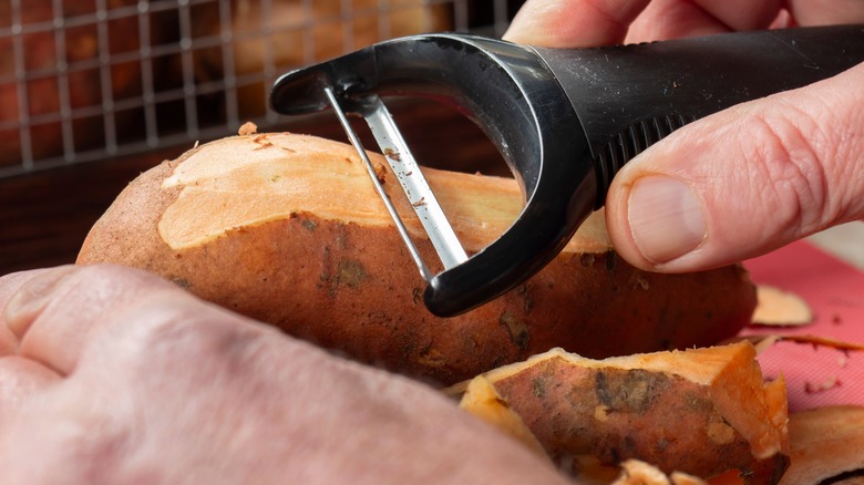 Person peeling sweet potato