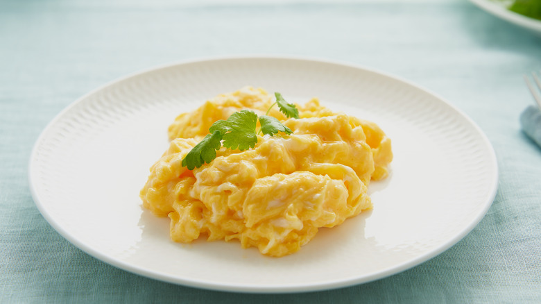 Soft scrambled eggs on white plate