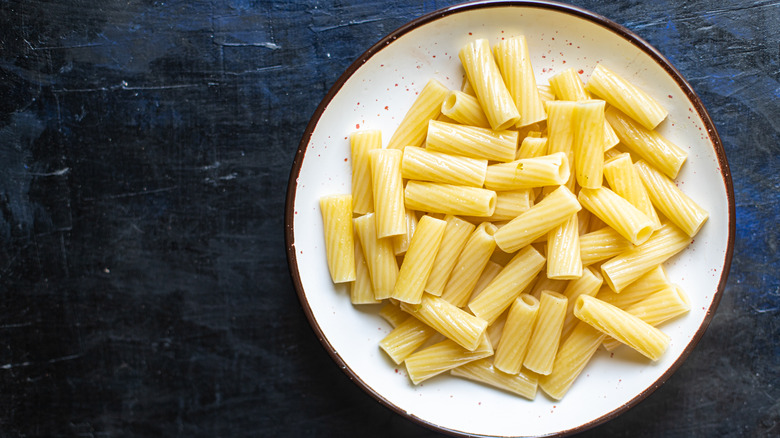 A bowl of ziti on a black surface
